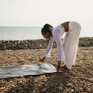 Ladina Yoga Warrior Black travel yoga mat laying on the ground