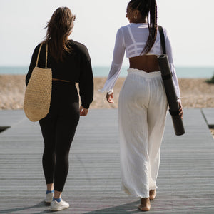 Warrior Black travel yoga mat walking by the beach